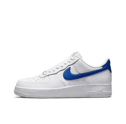 White low-top sneakers with blue Nike swoosh, lace-up design and perforated toe
