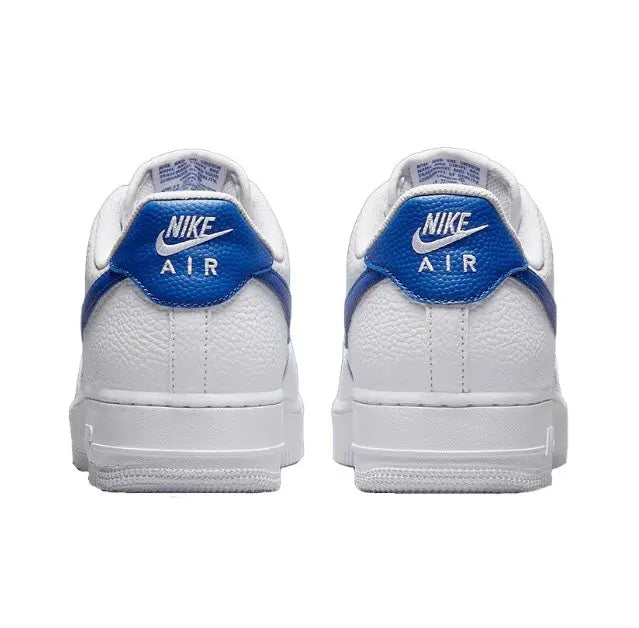 White low-top sneakers with blue heel tab and Nike Air branding on heel