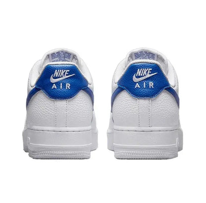 White low-top sneakers with blue heel tab and Nike Air branding on heel