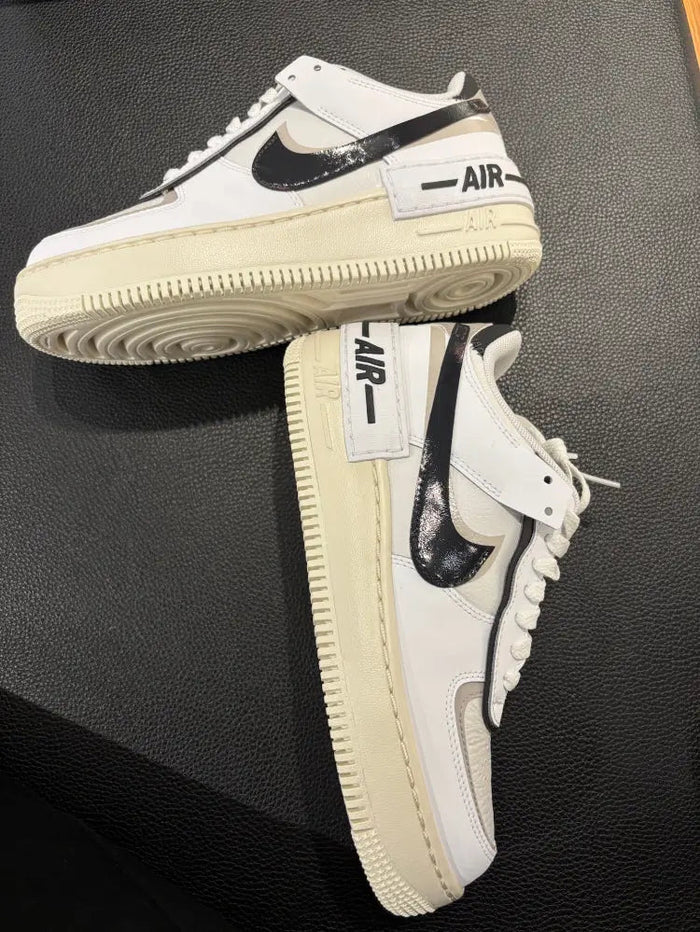 Nike low-top sneakers, off-white uppers with black swoosh and textured cream sole