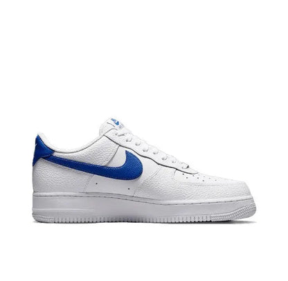 White low-top sneakers with blue swoosh panel and lace-up closure