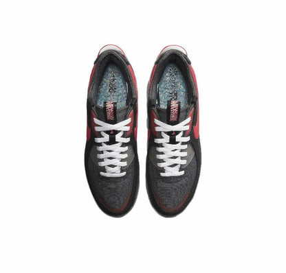 Nike Air Max 90 sneakers, top view; black uppers with red trim and white lace