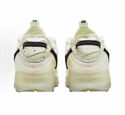 Nike Air Max 90 sneaker heel view, pale upper with black trim and white laces