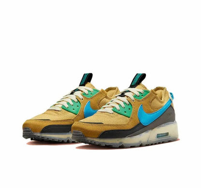 Nike Air Max 90 sneakers pair, wheat gold uppers with blue swooshes and green lace panels