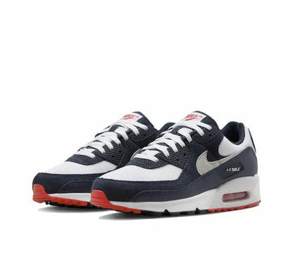 Nike Air Max 90 sneakers with white toe and grey swoosh, navy overlays, red outsole