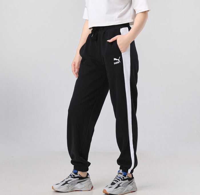 Black track pants with side white stripe, drawstring waist, Puma logo.