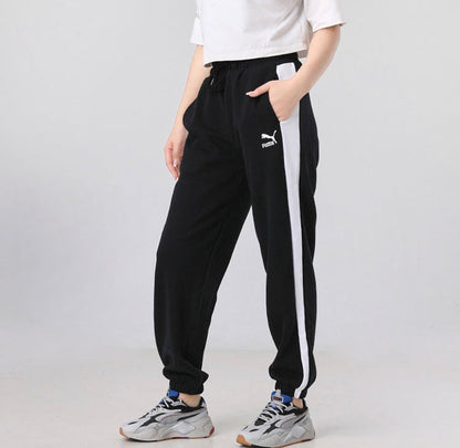 Black track pants with side white stripe, drawstring waist, Puma logo.