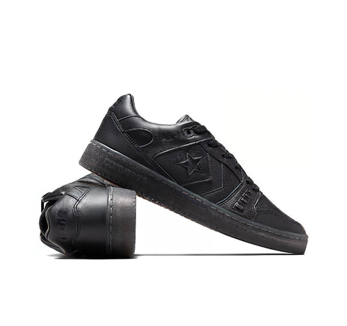Black low-top sneakers with star logo, lace-up upper and thick rubber sole