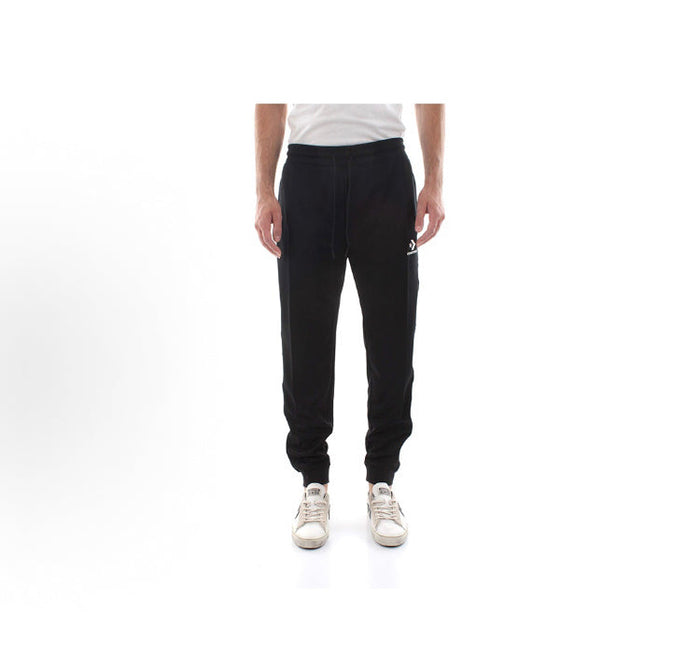Black track pants with white side stripe, worn with white low-top sneakers
