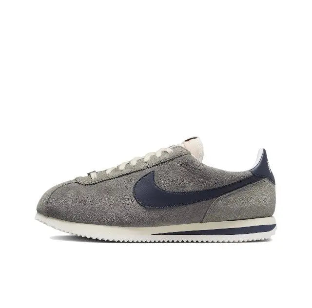 Grey Nike Cortez low-top sneakers with navy swoosh and white textured sole