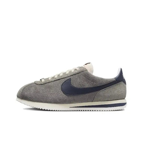 Grey Nike Cortez low-top sneakers with navy swoosh and white textured sole