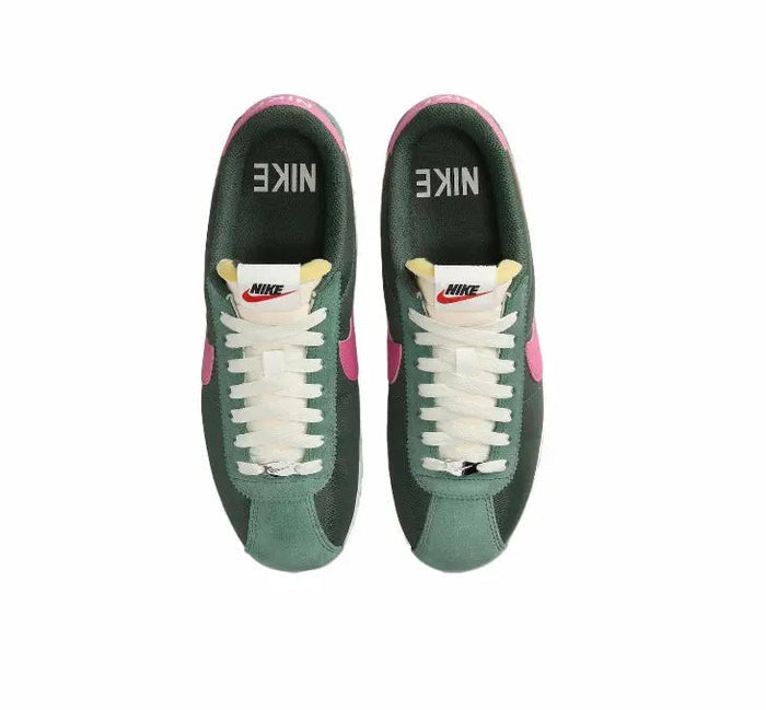 Nike Cortez sneakers with green uppers, white laces, and pink heel panel