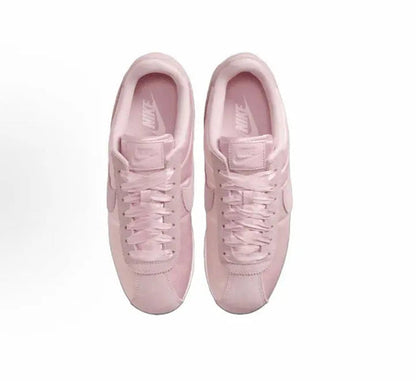 Pink Nike Cortez sneakers, pair view showing laces and cushioned tongue