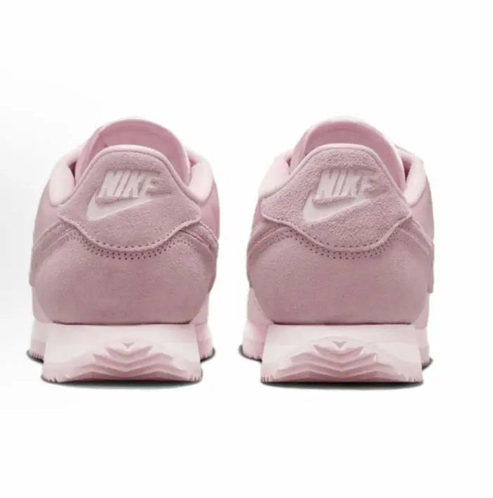 Pink Nike Cortez sneakers with NIKE branding on heel and flat rubber sole