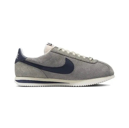 Grey Nike Cortez low-top sneakers with navy swoosh and lace-up details