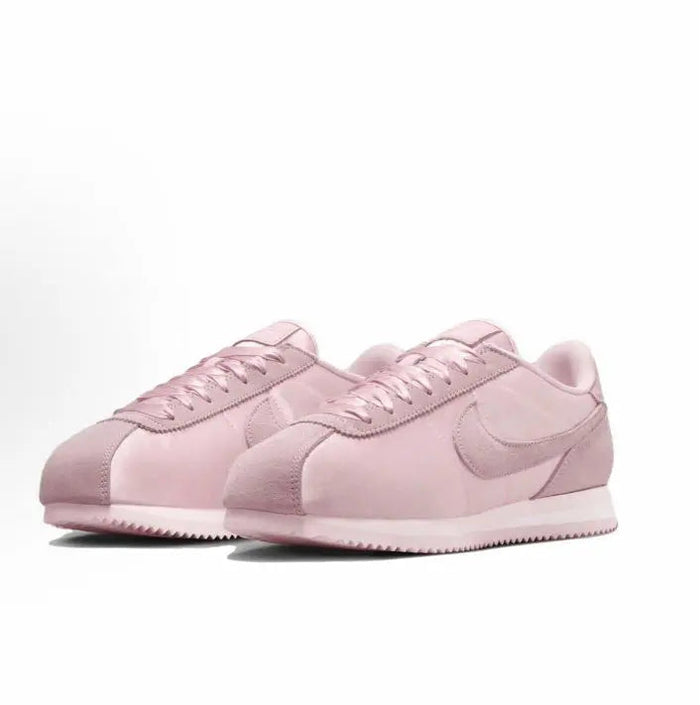 Pink Nike Cortez sneakers pair with laced uppers and Swoosh accents