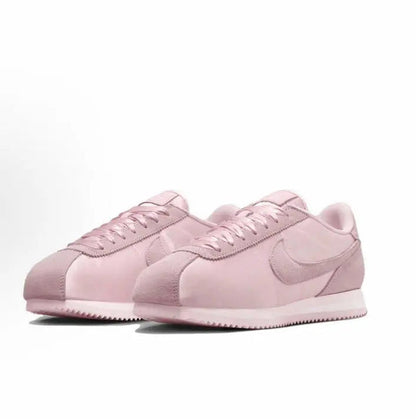 Pink Nike Cortez sneakers pair with laced uppers and Swoosh accents