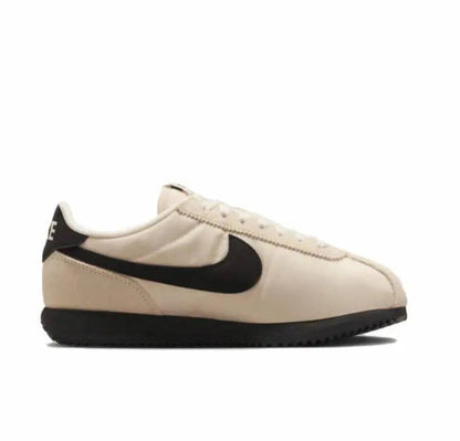 Nike Cortez sneakers side profile: light beige upper with black swoosh