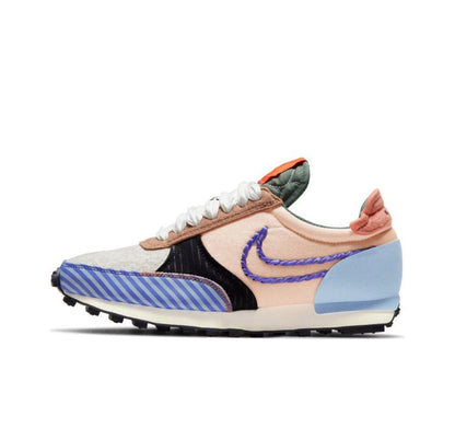 Nike Day Break sneaker side view with blue striped detail, black panel, and orange collar