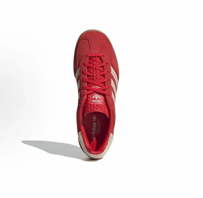 Red Adidas Gazelle Indoor sneaker, top view with red laces and Adidas branding.