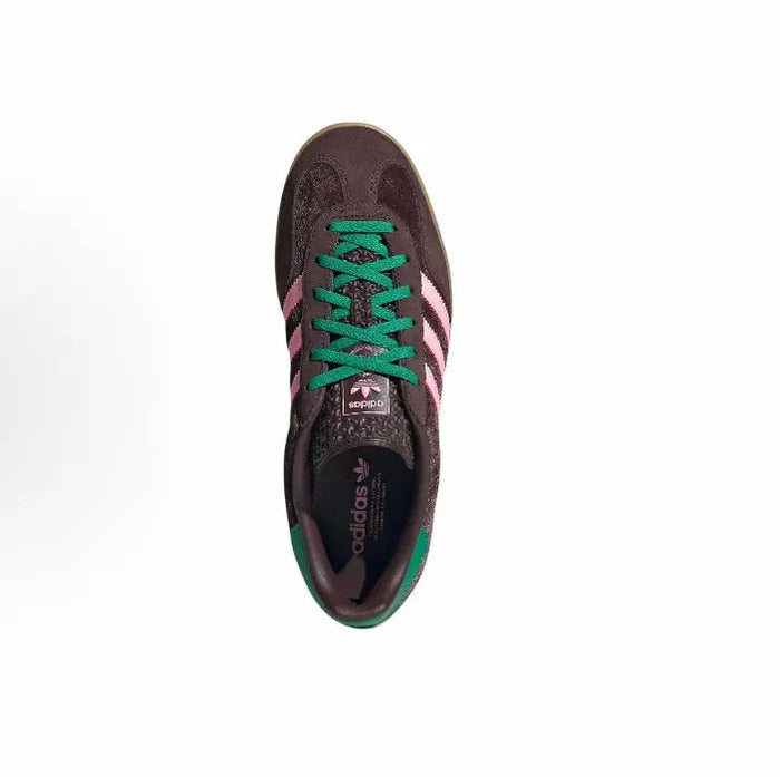 Adidas sneaker top view with green laces and pink stripe detail on dark upper
