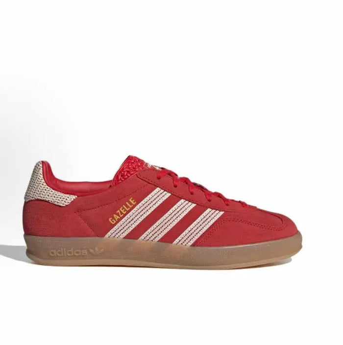 Red Adidas Gazelle Indoor sneaker side view with white stripes and gum outsole.