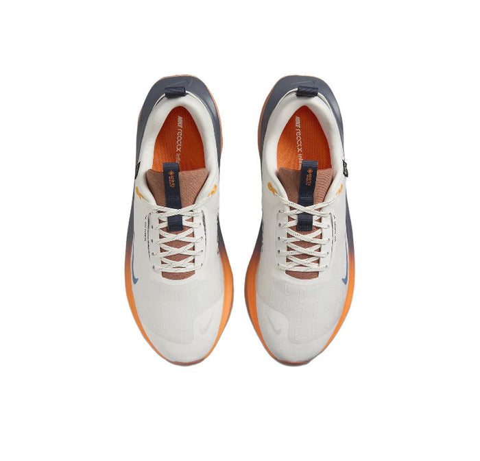 Nike Gore-Tex running shoes, cream uppers with white laces and blue heel accents