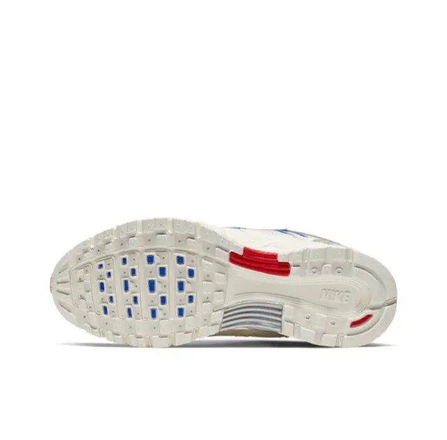 Premium running sneaker outsole view, white with blue traction pods and red heel tab