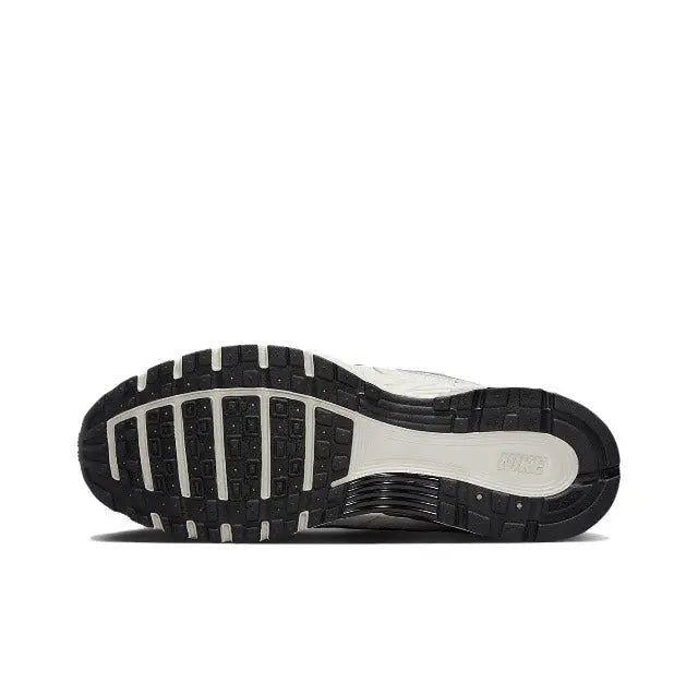 White running sneaker outsole with black traction tread and cushioned midsole