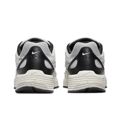 Back view white-and-black Nike running sneaker with black heel collar
