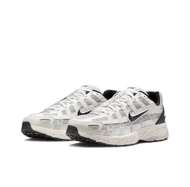 White-and-black lace-up running sneakers with cushioned, ribbed midsole