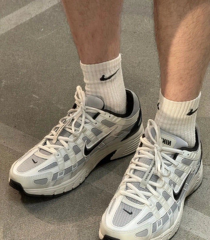 White-and-black Nike running sneakers worn with white crew socks