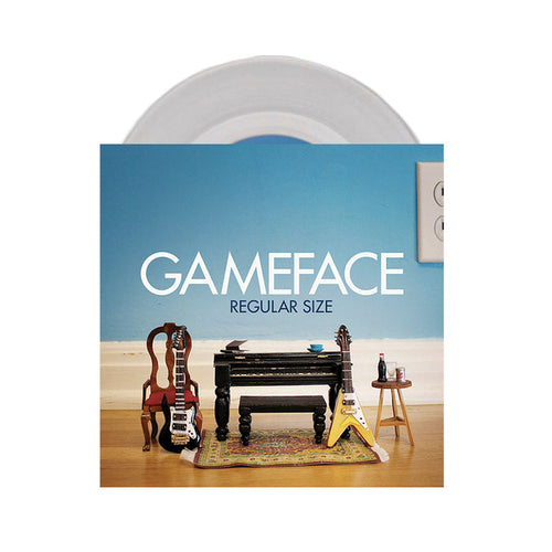 The Gameface album cover shows two toy guitars, a small chair, and a toy table on a rug by a blue wall, with a partially visible crystal clear vinyl record behind it.