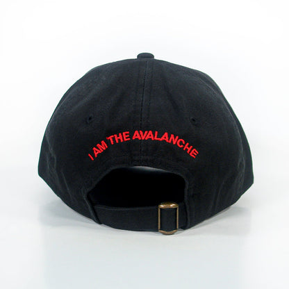 A black dad hat by I Am The Avalanche, shown from the back, features red “I AM THE AVALANCHE” text above an adjustable strap with a brass buckle.