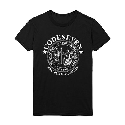 Black T-shirt with a white design. The word "CODESEVEN" is surrounded by stars around the seal of the state of North Carolina. Within the seal it states 'THE GREAT SEAL OF THE STATE OF NORTH CAROLINA" and "EST. 1995." Below the seal are the words "NC PUNK ALUMNI" surrounded in stars.