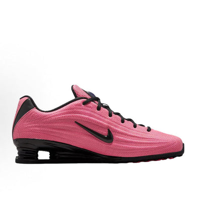 Pink running shoe side profile with black swoosh and black Shox midsole pods