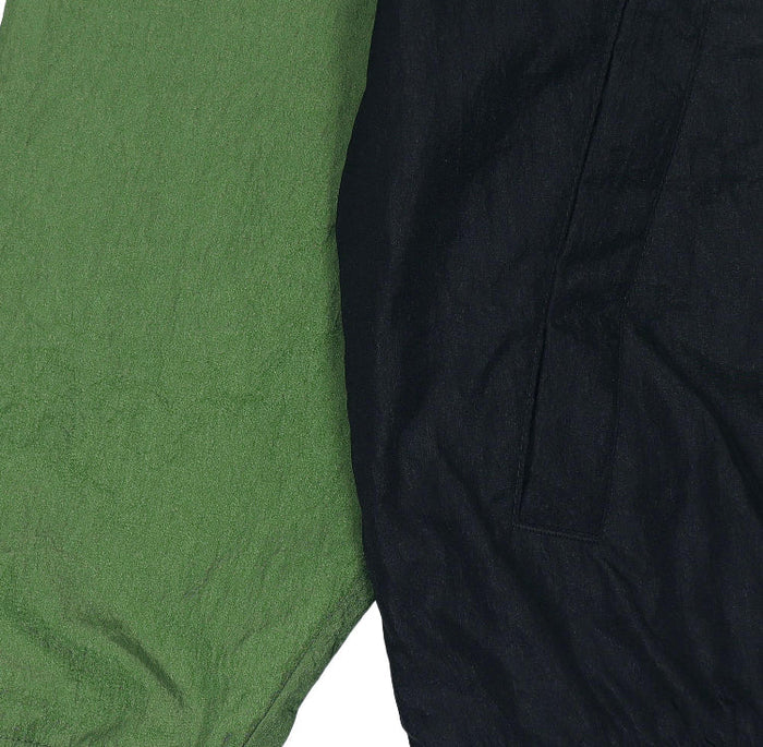 Green and black windbreaker fabric panel close-up with textured surface