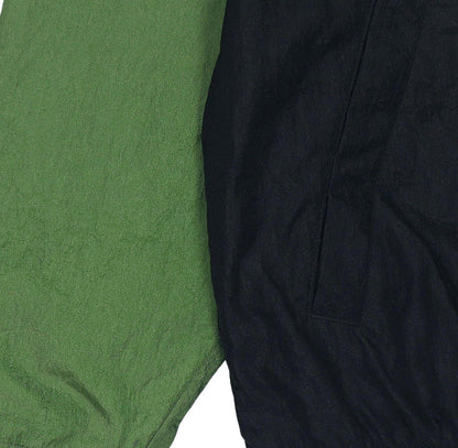 Green and black windbreaker fabric panel close-up with textured surface
