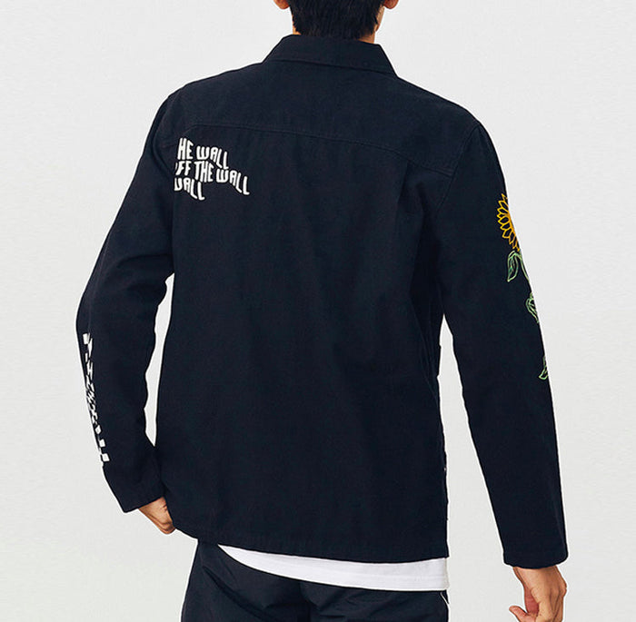 Vans black jacket on model with back text graphic and checkered sleeve panel