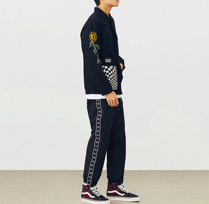 Vans black jacket side view with checkered sleeve patch and flower embroidery