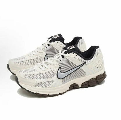 Nike running shoes: white/cream mesh upper with black swoosh and lace-up design