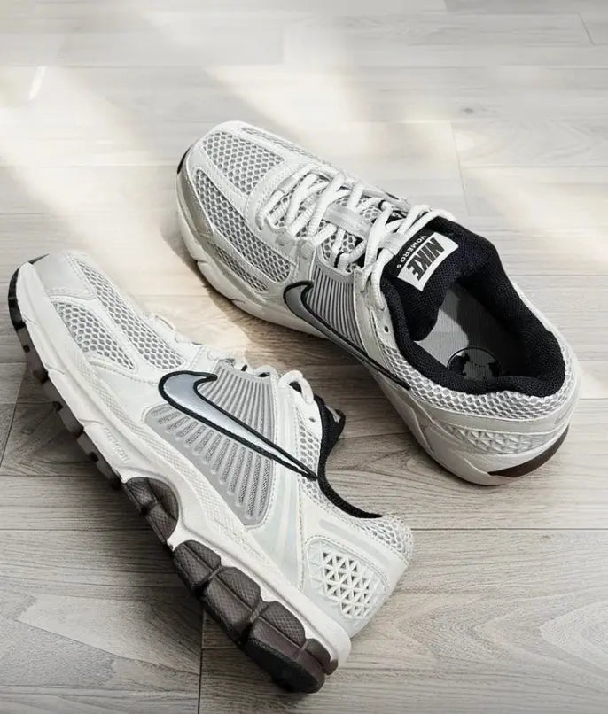 Nike running shoes pair: white mesh uppers with black swoosh, lace-up design